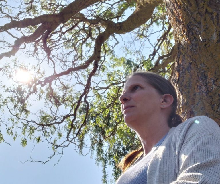 Nordseedünen mit blauem Himmel. Corinna sitzt mit Emmy in den Dünen.